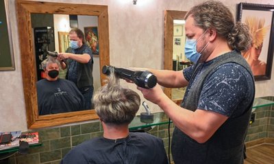 Edgar Krug bedient Kundin Sylke Nagel. Sein Salon hat Kunden verloren, aber auch neue gewonnen. 