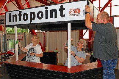 Veronika Gregor, Christine Wenig und Gerd Gregor (von links) brachten den Stand des Fanclubs "FanIce" im Eingangsbereich auf Vordermann.