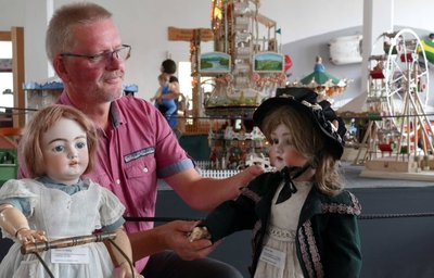 Hier rückt Depotleiter Michael Schuster einige Porzellankopfpuppen zurecht, die zu den Höhepunkten der Sommerschau gehören. 