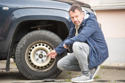 Michael Tägl, der Gornsdorfer Bürgermeister, zeigt auf ein Rad seines Autos. Unbekannte hatten am Fahrzeug seiner Partnerin, welches er auch regelmäßig nutzt, die Bolzen gelöst.
