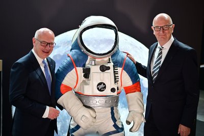 Kai Wegner (l, CDU), Regierender Bürgermeister von Berlin, und Dietmar Woidke (SPD), Ministerpräsident von Brandenburg, stehen neben einem Modell eines Weltraumanzuges.