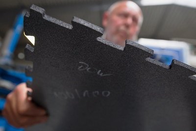 Andreas Baumann, Geschäftsführer der Mülsener Rohstoff- und Handelsgesellschaft mbH, zeigt eine Gummimatte aus Altreifen. Mit solchen Matten lassen sich zum Beispiel Werkhallen auslegen. 