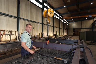 Mitarbeiter Jiri Pospisil ist mit Heftarbeiten an einem Dachrahmen beschäftigt. Der Rahmen gehört zum Bahnsteigdach „Typ Bodenheim“ für das Bauprojekt in München-Riem.