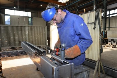 Mit dem Verputzen der Schweißnähte an einem Beleuchtungsträger ist Klaudiosz Gierzak befasst. Die Träger sind Teil des Bahnsteigdachs „Typ Zwiesel“ für das Projekt in Bad Vilbel.