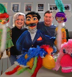 Maritta und Klaus Spindler mit Klappmaulpuppe Heini (Mitte), zwei Charlestontänzerinnen sowie Pinky und Fredy (vorn), die vor allem in Kinderprogrammen ihre Show abziehen. 