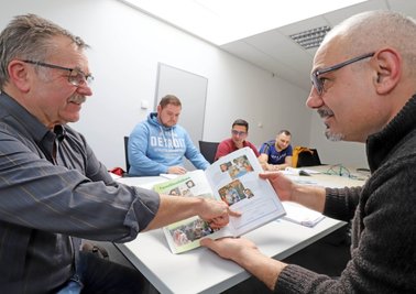 Deutschlehrer Dieter Zippenfennig (links) und Schüler Adrian Dorell Tobias (rechts) während des Deutschunterrichts für rumänische Mitarbeiter bei der Saxonia Edelmetalle GmbH in Freiberg. 