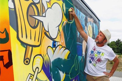 Der bekannte Graffiti-Künstler "Tasso" gestaltet den Toilettencontainer am Crimmitschauer Schützenplatz.