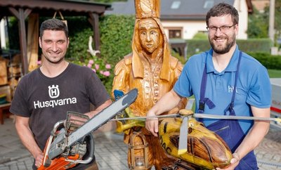 Mathias Kämpfer (links) hat schon etliche Kunstwerke per Kettensäge gezaubert - darunter den Bergmann (hinten) und das Modell des ADAC-Hubschraubers, den hier Muldenbergs Ortswehrchef Nils Golla hält. 