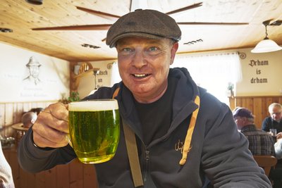 Frisch angekommen im Erzgebirge: Rainer Froberg aus Stuttgart kostet im Gasthaus „Zum Holzwurm“ in Neudorf das grüne Bier. Über die Osterfeiertage möchte er die Region erkunden und freut sich über diese besondere kulinarische Entdeckung.