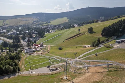 Die neue Allwetterrodelbahn zwischen Fly-Line und Vierersesselbahn aus der Vogelperspektive. Kritiker finden, die große Stahlkonstruktion verschandele die Landschaft. Für die Fahrgäste beim Start war das kein Thema.