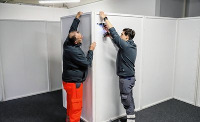 Erik Beitzel (r.) und Heinz-Michael Kirsten bei der Demontage der Trennwände im Impfzentrum. 