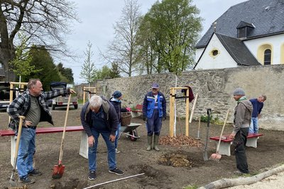 Helbigsdorfer halfen am Samstag beim Arbeitseinsatz im neuen Ortszentrum, im Hintergrund der Friedhof mit Kirche.