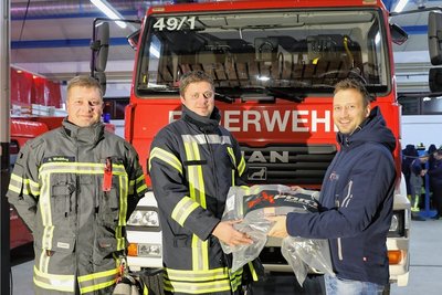 Gemeindewehrleiter Arnd Weißflog freut sich mit dem Markersbacher Ortswehrleiter André Krauß über die neue Einsatzkleidung, die Philipp Hartig von der Firma BTL aus Leipzig im Gepäck hatte (v. l.). 