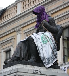 Die Statue des Gründers der Universidad de Chile, Andrés Bello, von Protestierenden in eine Dollarnote eingehüllt.