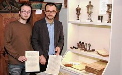 Fördervereinsvorsitzender Markus Stark (links) und Museumsleiter Michael Heuck haben die Vitrine mit wertvollen Exponaten bestückt und den Text auf der Urkunde, für alle lesbar, in der heutigen lateinischen Schrift noch einmal aufgeschrieben. 