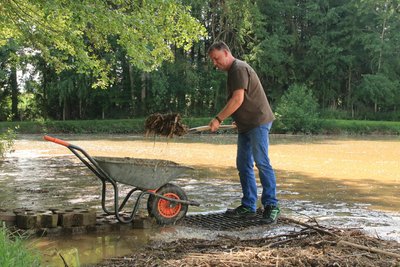 André Taubner und andere Helfer schaufelten nach dem Unwetter vom 31. Mai Schlamm, Geröll und Treibholz aus einem Treuener Teich.
