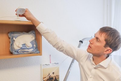 Professor Tom Schaal richtet den Sensor über dem Bett der Heimbewohner aus.