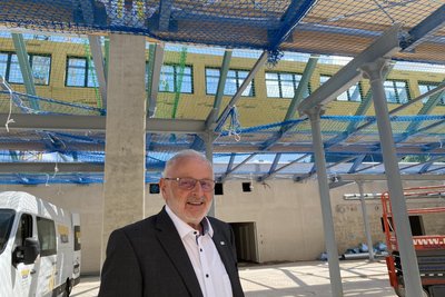 Bürgermeister Volker Bachmann freut sich schon aufs Einkaufen - rechts zu sehen sind die gusseisernen Säulen aus der abgerissenen Fabrik. Darüber die Nachbildung der alten Sheddächer.