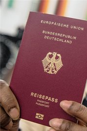 Eine aus Indien stammende Frau hält ihren neuen Pass in die Kamera. Nach Deutschland eingewanderte Menschen, sollen künftig - sofern sie ein qualifiziertes Aufenthaltsrecht haben - nach fünf, nicht wie bisher nach acht Jahren eingebürgert werden können.
