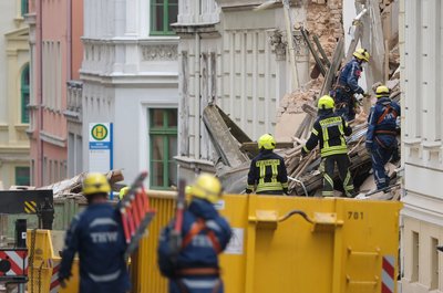 Einsatzkräfte suchen in den Trümmern eines eingestürzten Hauses nach Vermissten.