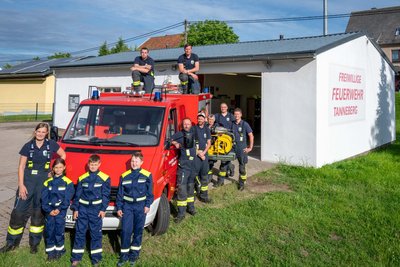 Mitglieder der Feuerwehr Tanneberg am bisherigen Gerätehaus, in dem es beengt zugeht.