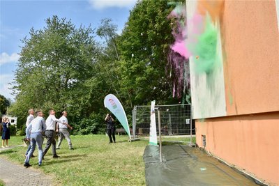 Das symbolische „Anwerfen" der Komplexsanierung mit bunten Farbkugeln an der Fassade, die komplett erneuert wird.