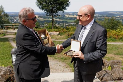 Nach der offiziellen Unterzeichnung des neuen Kooperationsvertrages tauschten der Landrat des Erzgebirgskreises, Frank Vogel (links) und der Chemnitzer Oberbürgermeister Sven Schulze noch Gastgeschenke aus: einen Bergmann und eine Stadtplakette. 