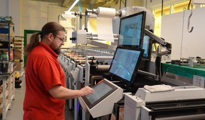 Enrico Herzog bedient die moderne Flexodruckmaschine, an der für das Trocknen der einzelnen Farben energiesparende LED-Technik angewendet wird. 