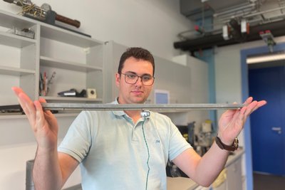 Promotionsstudent Peter Heinig zeigt mit einem Supraleiter, wie er Gegenstände zum Schweben bringt.
