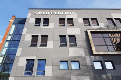 Das Stadtarchiv wird kurz vor dem 25. November nachts orange angestrahlt.