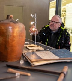 Vor Saisonbeginn erfolgt stets eine Grundreinigung des Hauses, Ausstellungsstücke und Installationen werden bei Bedarf ausgebessert. Hausmeister Michael Göhler kontrolliert hier die Leuchten in einer geöffneten Vitrine.