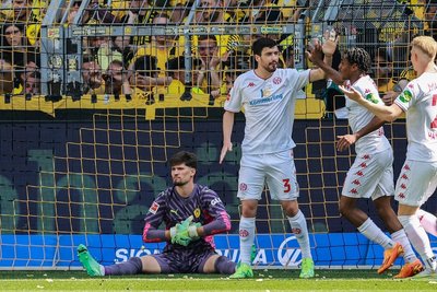 Dortmunds Torwart Gregor Kobel (l.) sitzt am Boden, nachdem Mainz 05 das 0:2 aus Sicht der Dortmunder Hausherren erzielt hat.