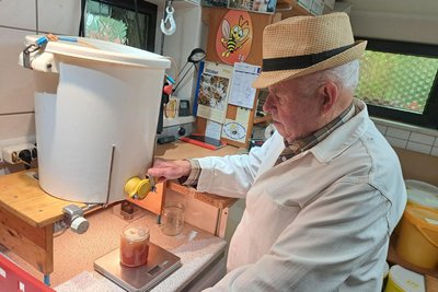 Horst Süß füllt den süßen Honig in Gläser ab.