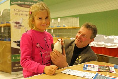 Die siebenjährige Klara durfte eine Sächsische Schildtaube streicheln. Ausstellungsleiter Mike Kunstmann freut sich über das Interesse.