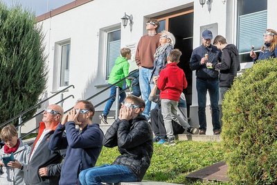 Besucher beobachten die Sofi mit einer Spezialbrille vor der Volkssternwarte Drebach.