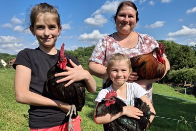 Kristin Hübner mit ihren Töchtern Lotta und Sophia und Hähnen, die wohl um die Wette krähen.
