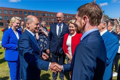 Bundeskanzler Olaf Scholz (SPD, 2.v.l.) wird beim Besuch der Konferenz der ostdeutschen Regierungschefs auf der Ostseeinsel Riems von Michael Kretschmer (CDU, r), Ministerpräsident von Sachsen, begrüßt.
