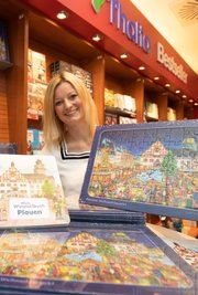 Sophie Gürtler vom Dachverband Stadtmarketing mit dem neuen Puzzle und dem Plauener Wimmelbuch. 
