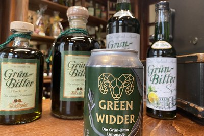 „Green Widder“ und seine Grünbitter-Verwandtschaft. Links die legendäre und 32-prozentige Ursuppe, rechts die im Vorjahr herausgekommene Spritz-Variante mit etwa 15 Prozent Alkohol und vorn der Grünbitter als Limonade – mit einem eher platonischen Alkoholgehalt.
