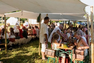 Zwei lange Bänke und in der Mitte das gespielte Brautpaar: Das Gelage des Historischen Besiedlungszugs ist vor allem für die teilnehmenden Siedler ein Höhepunkt. Besucher sind für den Moment nur Zaungäste. 