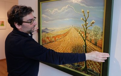 Auf dem Foto präsentiert Galerieleiter Alexander Stoll ein Ölgemälde von Werner Franz