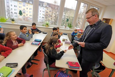 Oberbürgermeister Sven Krüger übergibt die Kinotuscheine an die Böhme-Grundschüler.
