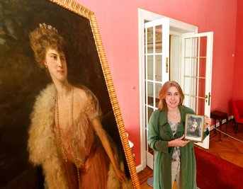 Lara Klewin am Porträt der Fürstin Elenore von Schönburg-Waldenburg in der Beletage des Schlosses. In der Hand hält sie ein Bildnis des Fürsten Otto Victors II. 