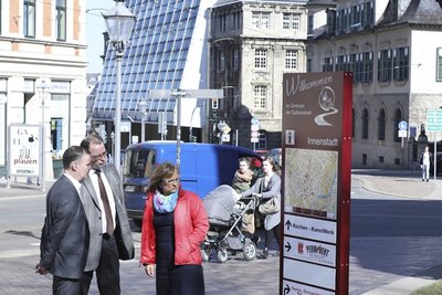 Sven Erlewein von der Klimm GmbH & Co. KG, die die Willkommenstafeln herstellt, Eckhard Sorger und Sylvia Weck begutachten ein Schild, das am Dienstag an der Neundorfer Straße aufgestellte wurde.