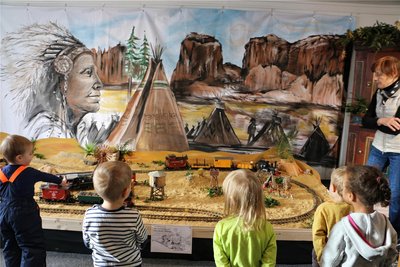 Hingucker ist das große Wandbild mit der Eisenbahnlandschaft davor.