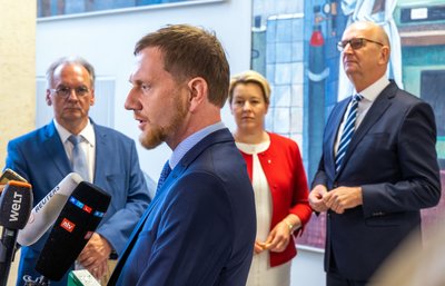 Michael Kretschmer (CDU), Ministerpräsident von Sachsen, spricht vor dem Beginn der Konferenz ostdeutscher Regierungschefs auf der Ostseeinsel Riems mit Medienvertretern und wird von Dietmar Woidke (SPD, r-l), Ministerpräsident von Brandenburg, Franziska Giffey (SPD), Regierende Bürgermeisterin von Berlin, und Reiner Haseloff (CDU), Ministerpräsident von Sachsen-Anhalt, beobachtet.