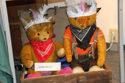 Die wilden Bären sind die als Indianer verkleideten großen Teddys, die etwa in Koffern sitzen.