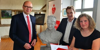 Museumsleiterin Sibylle Karsch, Sparkassenchef Hans-Ferdinand Schramm (l.) und Oberbürgermeister Ralf Schreiber mit der restaurierten Schilling-Büste von Königin Carola und dem Fördermittelbescheid. 
