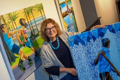 Künstlerin Birgit Mehnert mit dem Bild mit Titel "Wohin" in der Hand, das hinter ihr heißt "Duo". 
