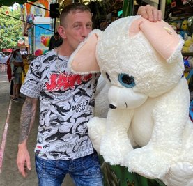 Ein Knutscher für das Kuscheltier: Dyksa Wojcich arbeitet auf dem Rummel und es macht ihm Spaß, wie er auf dem Foto beweist. 